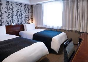 Una habitación de hotel con dos camas y una ventana. en APA Hotel Haneda Anamori Inari Ekimae, en Tokio
