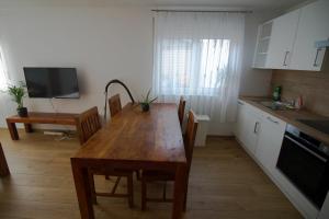 una cucina con un tavolo di legno con sedie e un lavello di BodenseeLicht Studio Tettnang a Tettnang