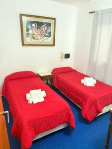 马德普拉塔Hotel Lacar的红色床单的客房内的两张床
