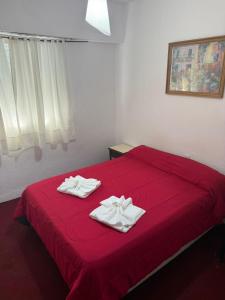 马德普拉塔Hotel Lacar的红色的床,上面有两条毛巾