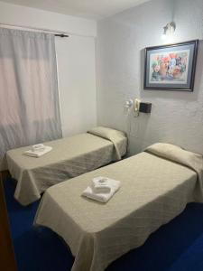 马德普拉塔Hotel Lacar的酒店客房设有两张床和电话