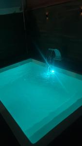 una persona in una piscina d'acqua con una luce blu di Casa unahome a Cabo Frio
