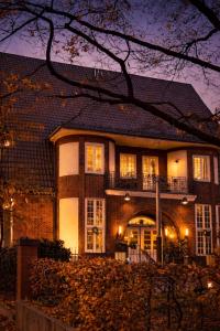 a large brick house with a balcony at night at Sleephotels Suite Garde in Hamburg +66 photos