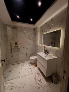 een witte badkamer met een wastafel en een spiegel bij Appartement T3 Terrasse in Frontenex-Villard-Rosset