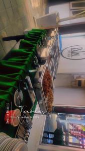 a shelf in a kitchen with green cloth and tools at Goldenwesthotelcasino in Nieuw Nickerie +2 photos