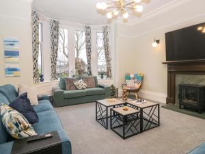 ein Wohnzimmer mit einer blauen Couch und einem Kamin in der Unterkunft Rocklands in Shap