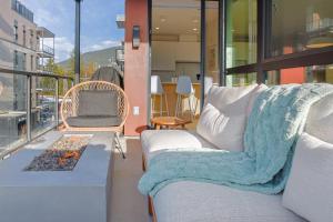 a living room with a couch and a fireplace on a balcony at Cedar Vista - condo with stunning mountain views in Revelstoke +28 photos