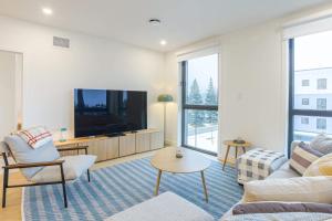a living room with a tv and a couch at Cedar Vista - condo with stunning mountain views in Revelstoke