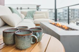 four coffee mugs sitting on a table in a living room at Cedar Vista - condo with stunning mountain views in Revelstoke