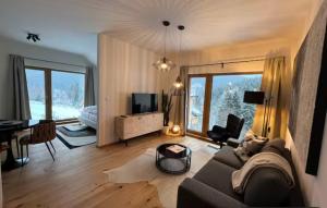 ein Wohnzimmer mit einer Couch und einem Tisch und einem Fernseher in der Unterkunft Golden Ridge Apartments in Špindlerův Mlýn