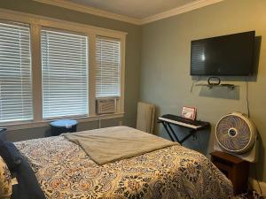 a bedroom with a bed and a flat screen tv at Casa Castor • Private Room 2 in Chelsea