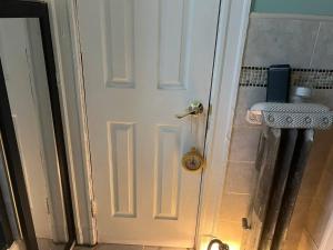 a white door in a bathroom with a sink at Casa Castor • Private Room 2 in Chelsea +2 photos