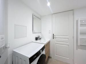 un bagno bianco con lavandino e specchio di Le BEAU LOUIS a Lione