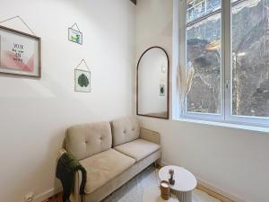 un soggiorno con un divano e una finestra di Le BEAU LOUIS a Lione