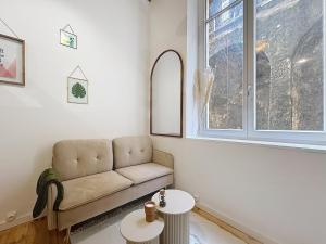 un soggiorno con un divano e una finestra di Le BEAU LOUIS a Lione