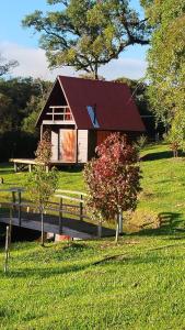 ein kleines Haus mit rotem Dach auf einem Feld in der Unterkunft Refúgio Serrano in São Francisco de Paula