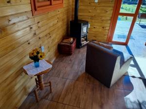 a living room with a couch and a stove at Refúgio Serrano - Cabana in São Francisco de Paula