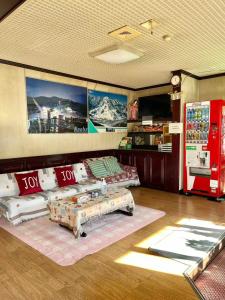 een woonkamer met een bank en een salontafel bij 苗場ウッドインだいまる in Yuzawa