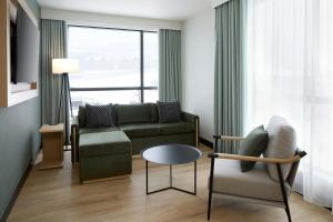 een woonkamer met een bank en een tafel bij Residence Inn by Marriott Bromont in Bromont