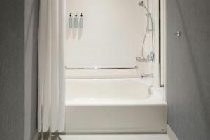 een wit bad met een douchegordijn in de badkamer bij Residence Inn by Marriott Bromont in Bromont +24 foto's