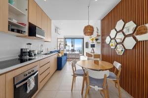 a kitchen and dining room with a table and chairs at Modern Ocean View Apartment Private Balcon in Nuevo Nayarit