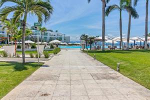 a walkway leading to the pool at the resort at Modern Ocean View Apartment Private Balcon in Nuevo Nayarit