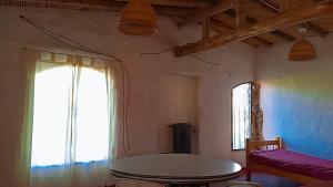 a living room with a table and a window at Nativas Cabaña Amarilla in Senador Pérez