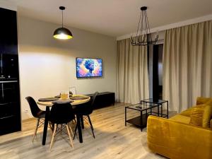 een woonkamer met een tafel, stoelen en een bank bij Apartament Jurowiecka 17 in Białystok