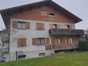 a house with wooden doors and windows on it at Logement du Bois de Chaubon in Fillinges