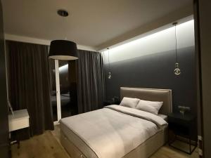 een slaapkamer met een groot bed met een zwarte muur bij Apartament Jurowiecka 17 in Białystok