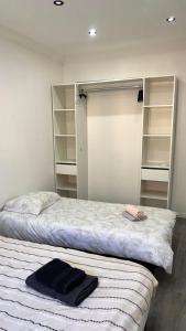 una camera da letto con due letti e un armadio con scaffali di Appartement T2 a Randens Altre 24 foto