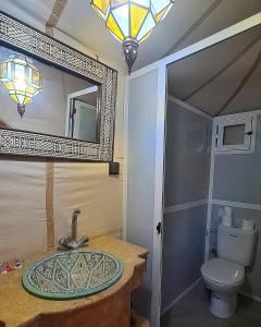 a bathroom with a sink and a mirror and a toilet at Luxury Desert Camp Merzouga in Merzouga +53 photos