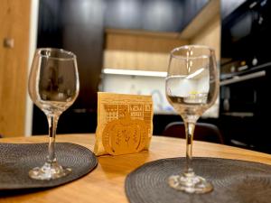 twee wijnglazen bovenop een houten tafel bij Apartament Jurowiecka 17 in Białystok