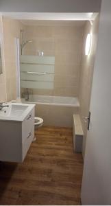 ein Badezimmer mit Waschbecken, Badewanne und Toilette in der Unterkunft Appart'Hotel Lizon Cocooning avec sauna in Lavans-lès-Saint-Claude