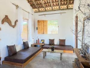 a living room with two couches and a table at Anahi Caraiva in Caraíva