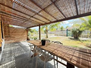 a wooden table and chairs under a wooden pergola at Anahi Caraiva in Caraíva +7 photos