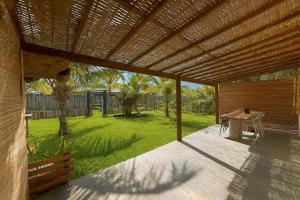 an external view of a patio with a wooden pergola at Anahi Caraiva in Caraíva