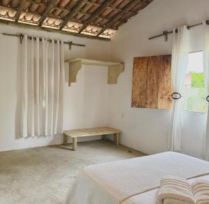 a bedroom with a bed and a wooden table at Anahi Caraiva in Caraíva