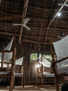 a room with two beds and a ceiling fan at Your Zanzibar Place in Paje
