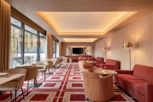 a restaurant with red couches and tables and windows at AC Hotel Atocha by Marriott in Madrid