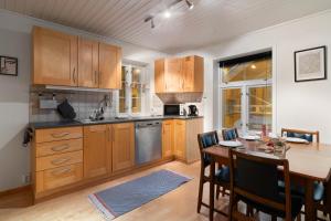 una cucina con mobili in legno e un tavolo con sedie di ARCTIC HOMES - The Charming House a Tromsø