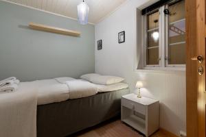 una piccola camera da letto con un letto e una finestra di ARCTIC HOMES - The Charming House a Tromsø Altre 5 foto
