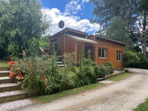 ein kleines Holzhaus mit einem Weg dorthin in der Unterkunft Quaint Country Cottage 