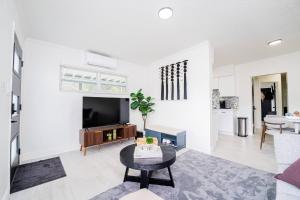 a living room with a tv and a table at Close to the Action, Peaceful When You Return in Orlando