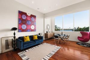 a living room with a blue couch and a table at Opera House Retreat - Opera House & Bridge View in Sydney