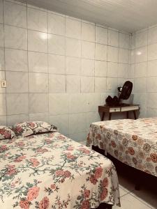 a room with two beds and a table with a chair at Casa no coração de Areia in Areia