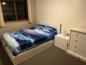 een slaapkamer met een bed, een ladekast en een raam bij Rosebud Beach Haven in Rosebud