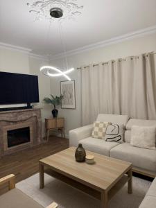 een woonkamer met een bank en een tv bij The quinta in Quinta do Conde