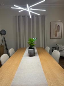 een vergaderruimte met een houten tafel en een potplant bij The quinta in Quinta do Conde