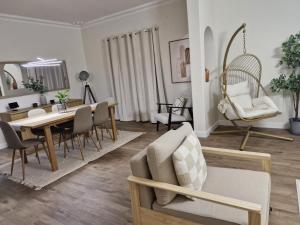 een woonkamer met een eettafel en stoelen bij The quinta in Quinta do Conde